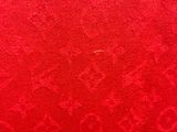 red fabric with a pattern of flowers and leaves on it