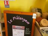 un tableau noir sur lequel est inscrit un menu, dans une cuisine