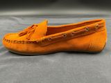 a close up of a pair of orange shoes on a gray surface