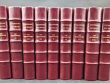 six livres rouges sont empilés les uns sur les autres sur une table