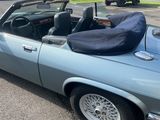 a blue convertible car parked in a parking lot