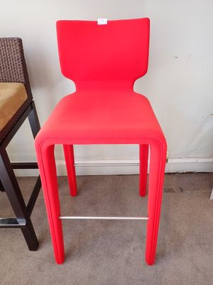 une chaise rouge placée à côté d'un tabouret de bar