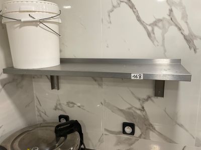 a bucket on the shelf above the stove in the kitchen