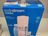 une boîte de Sodastream posée sur une table à côté d'une boîte de sodas