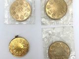 trois pièces d'or dans des sachets en plastique posées sur une surface blanche