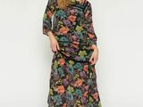 une femme vêtue d'une robe noire à fleurs et de chaussures noires