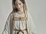 a statue of a woman in a white dress with a flower crown on her head
