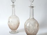 pair of antique cut glass decanters on pedestals on a white background