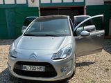 une voiture de couleur argentée garée devant un bâtiment