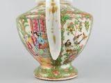 a vase with a handle that has a picture of a woman on it