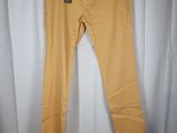 a pair of yellow pants hanging on a hanger in front of a white curtain