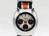 an orange and white watch with a black and white stripe strap
