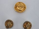 three pieces of gold are shown on a white surface