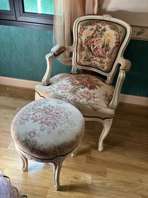 un fauteuil et un pouf dans un coin de la pièce
