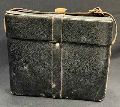 an old black briefcase with a brown strap on a black background