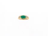 a gold ring with a green stone and two diamonds