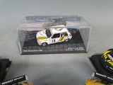 three toy cars in a clear box on a table