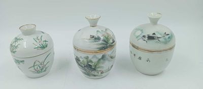 trois vases blancs ornés de motifs, posés sur une surface blanche