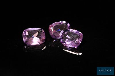 a pair of purple amethtites sitting on top of a black surface