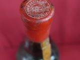 a bottle of wine that is sitting on a red cloth