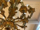 a gold chandelier hanging from the ceiling in a room