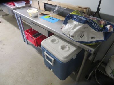 an image of a kitchen area with a table and a cooler