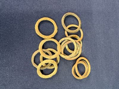 several pieces of gold colored metal rings on a blue cloth