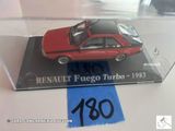 une petite voiture rouge dans une vitrine posée sur une table