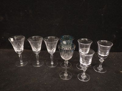 Plusieurs verres à vin vides sont alignés sur une surface noire