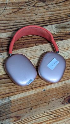 pair of pink headphones sitting on top of a wooden table