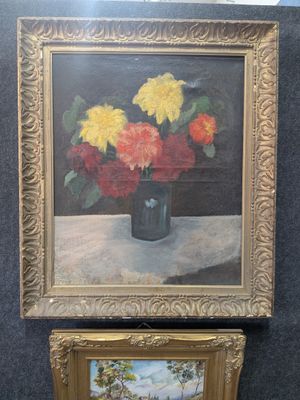 tableau représentant des fleurs dans un vase posé sur une table, à côté d'un tableau représentant un paysage