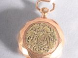 a gold pocket watch with a chain on a white surface