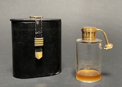 a small bottle of perfume next to a black case