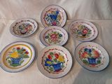 six assiettes ornées de motifs différents, disposées sur une nappe blanche