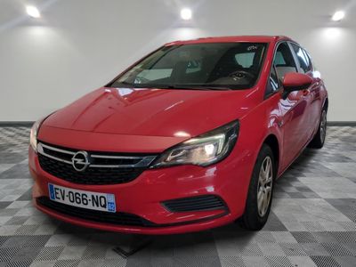Une Opel rouge est garée dans une pièce dont le sol est en damier.