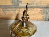 antique brass plated oil lamp with a bird on top of it