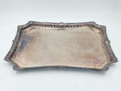 un plateau argenté avec une poignée sur une surface blanche