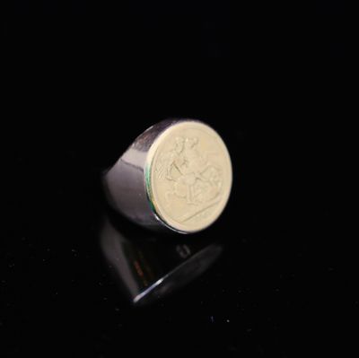 un gros plan d'une bague sur laquelle est posée une pièce de monnaie