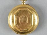 an image of a gold pocket watch on a white surface