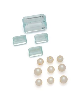 un assortiment de perles et un morceau de verre sur un fond blanc