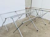 three clothes drying racks in a room with a white board