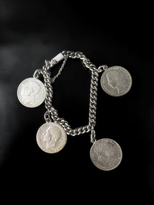 un gros plan d'un bracelet à maillons orné de pièces de monnaie