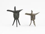 pair of bronze figurines of a man and a woman holding a knife