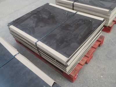 Plusieurs blocs de granit noir sont empilés sur une palette
