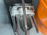 un grand seau orange posé par terre à côté d'un bac en métal