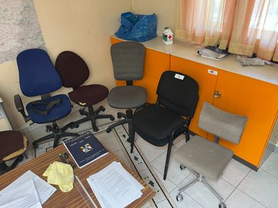 plusieurs chaises de bureau et un bureau dans une pièce aux murs orange
