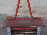 a red lawn mower that is sitting on the ground