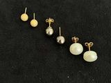 three pairs of pearl and gold earrings on a black background