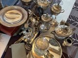 une table sur laquelle sont disposés plusieurs assiettes et couverts en argent