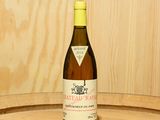 une bouteille de vin posée sur un tonneau en bois